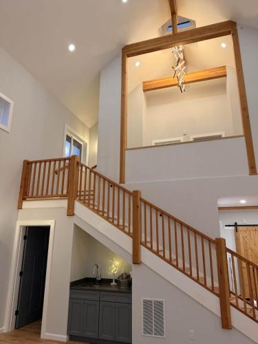 a stairway in a house with a wooden railing at Vineyard Room @ Boulder Mountain View Barn in Twin Mountain