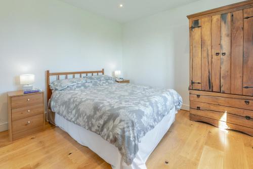 a bedroom with a large bed and a wooden dresser at 3 Bed in Shebbear oc-l32582 in Shebbear