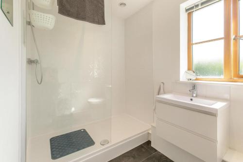 a white bathroom with a shower and a sink at 3 Bed in Shebbear oc-l32582 in Shebbear