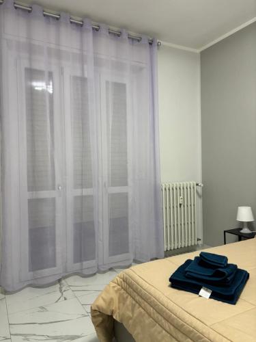 een slaapkamer met een bed met blauwe handdoeken erop bij GioNi HOUSE in Collegno