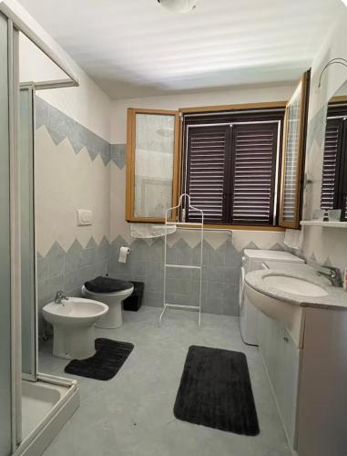 a bathroom with two sinks and a toilet and a shower at B&B Maria appartamento con stanza matrimoniale e soggiorno vicino alla fiera 2 in Rimini