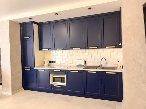 a kitchen with blue cabinets and a sink at Golden Bugas Sea View Золотий бугаз in Karolino-Buhaz