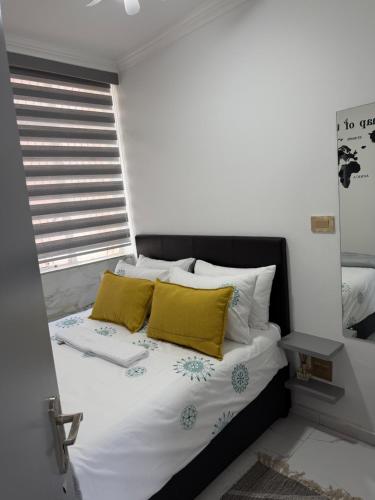 a bedroom with a bed with yellow pillows at Flowsort Grand Apartments 2 in Durban