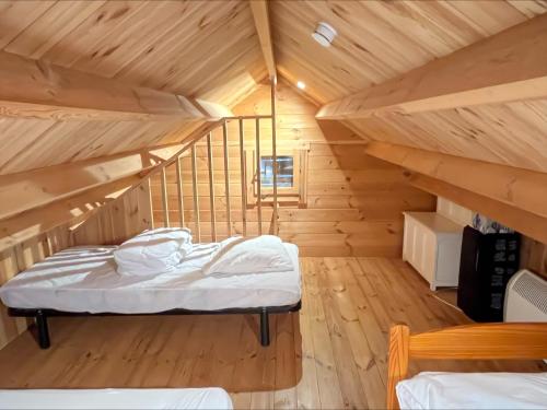 a bedroom with a bed in a wooden room at Chalet en lisiere de Foret in Lacanau