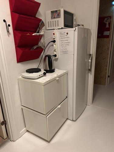 een keuken met een koelkast en een tafel met een magnetron bij Blomsterhaven in Glesborg