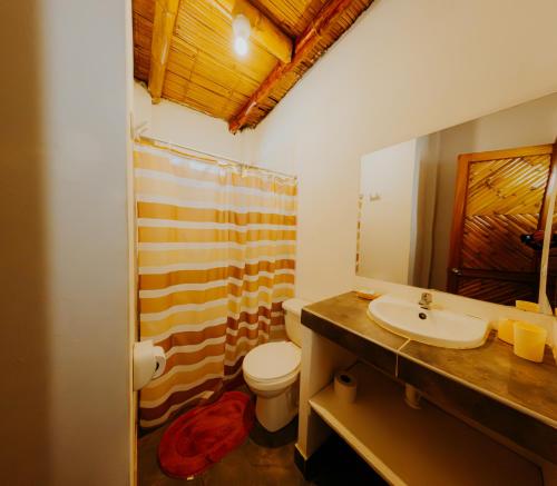 un bagno con lavandino, WC e doccia di Bungalows Sol y Mar a Canoas De Punta Sal