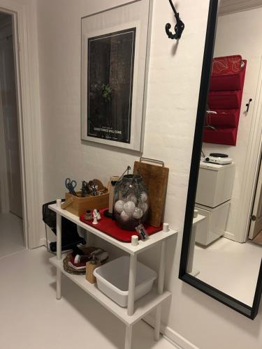 een spiegel en een plank met een aantal spullen erop. bij Blomsterhaven in Glesborg