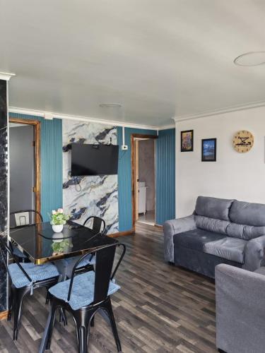 蓬塔阿雷纳斯Ruka Austral的客厅里有一张沙发和一张桌子。