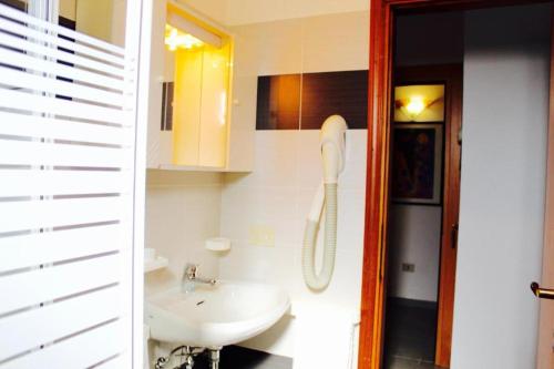 a bathroom with a sink and a phone in it at Hotel President in Cesenatico