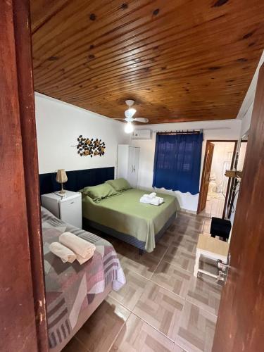 a bedroom with a bed and a bed and a table at Hospedaria de Maria in Tiradentes