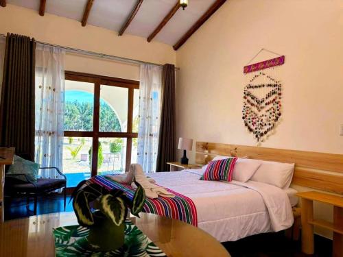 a bedroom with a bed and a table and a window at Fundo Alma Andina in Jauja