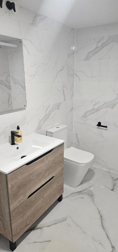 a white bathroom with a sink and a toilet at Alicante 30 in Alicante