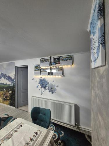 een slaapkamer met witte muren en een blauwe stoel bij Casa Petra in Sărata-Monteoru