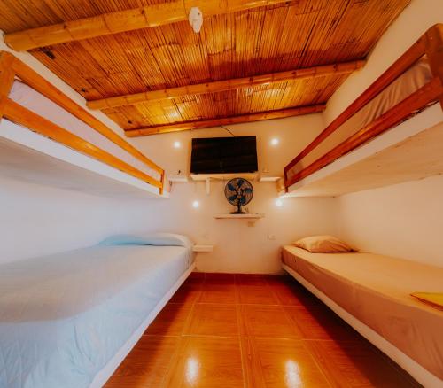 una camera con due letti e una TV sul soffitto di Bungalows Sol y Mar a Canoas De Punta Sal
