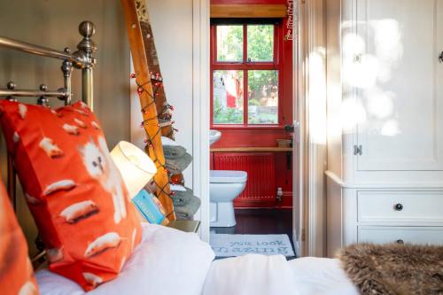 a bedroom with a bed and a bathroom with a toilet at River Cottage at Old Post Office in Bardon Mill