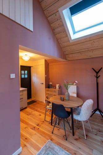 a kitchen with a table and chairs and a skylight at Houten huisje met keuken en tuin in Halsteren, Bergen op Zoom in Halsteren