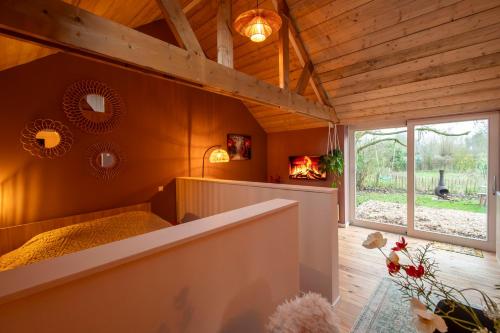 a room with a fireplace in a house at Houten huisje met keuken en tuin in Halsteren, Bergen op Zoom in Halsteren