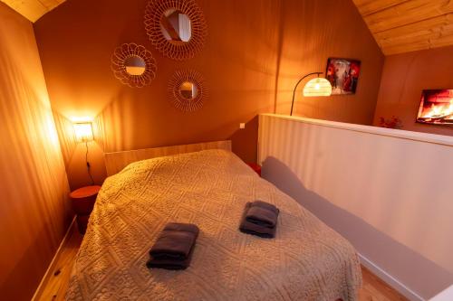 a bedroom with a bed with two bags on it at Houten huisje met keuken en tuin in Halsteren, Bergen op Zoom in Halsteren