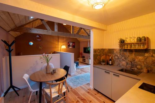 a kitchen and dining room with a table and a counter at Houten huisje met keuken en tuin in Halsteren, Bergen op Zoom in Halsteren