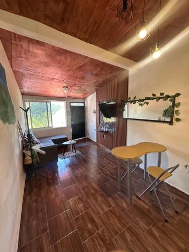 a living room with wooden floors and a table and chairs at El Refugio del Viajero in Mineral del Chico