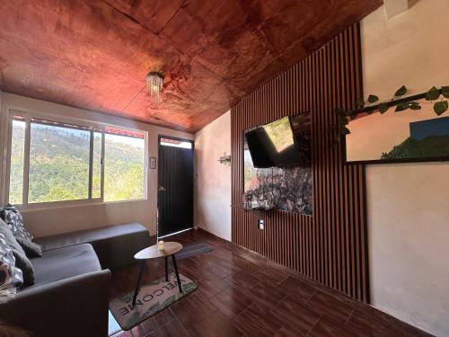 a living room with a couch and a tv at El Refugio del Viajero in Mineral del Chico