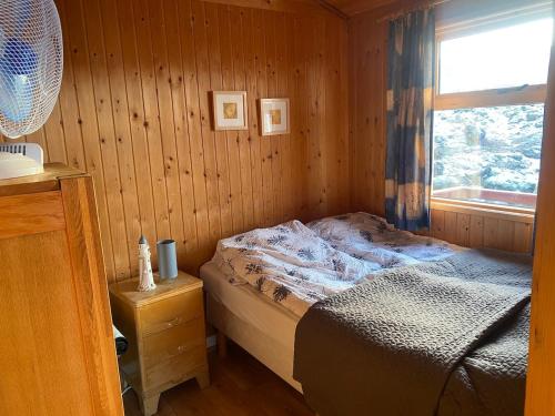 a bedroom with a bed in a room with a window at A cosy 2 bedroom cabin with an amazing view in Borgarnes