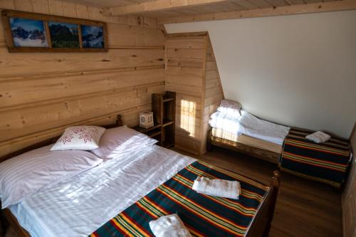 a bedroom with a bed in a log cabin at Apartamenty na starej drodze in Witów