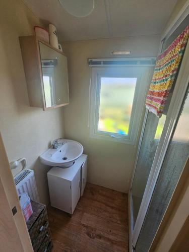 ein kleines Badezimmer mit Waschbecken und Fenster in der Unterkunft Number34 in Drummore