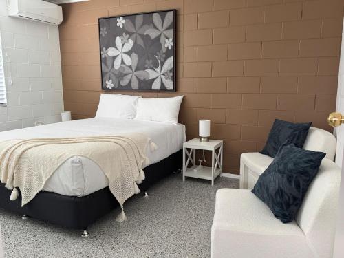 a bedroom with two beds and a chair in it at Large Earthy toned Apartment in Ross River
