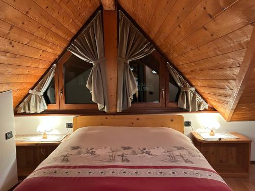 un letto in una camera con una grande finestra di Casa Mezzavalle a Pelugo