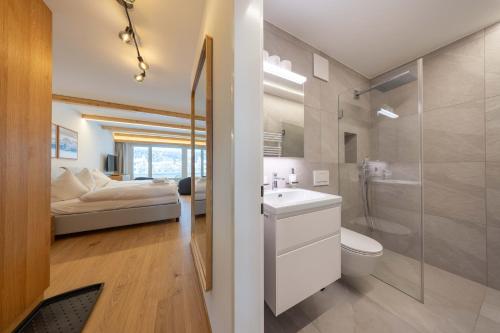 a bathroom with a sink and a toilet and a bed at New Exclusive Studio with Fireplace, Pool & Sauna in St. Moritz