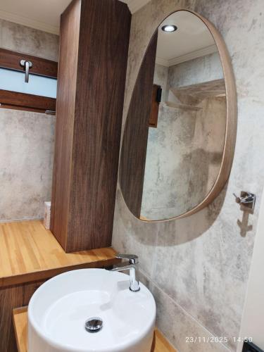 a bathroom with a sink and a mirror at Φεγγαρόπετρα ΓΑΙΟΦΩΣ in Kalívia