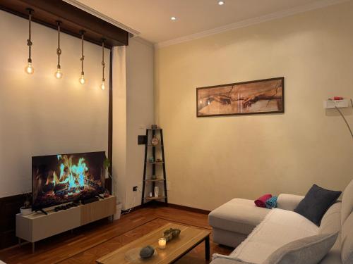 ein Wohnzimmer mit Sofa und Flachbildfernseher in der Unterkunft Loft 84 in Piacenza