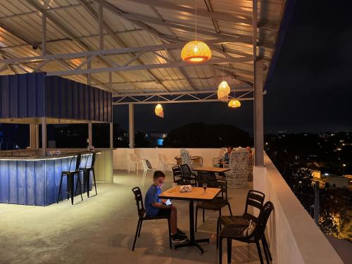 un ragazzino seduto a un tavolo in un patio di Mi lugar de descanso a Moca