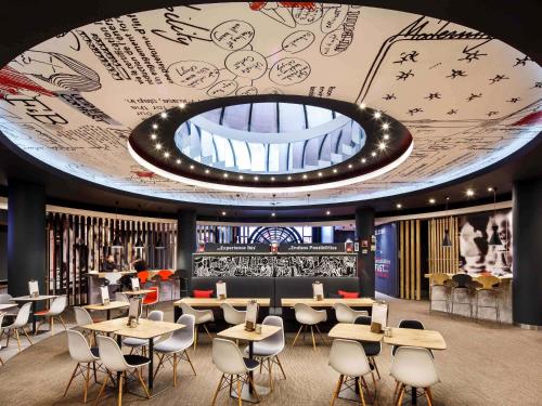 un ristorante con tavoli e sedie e un grande soffitto di ibis Birmingham Centre New Street Station Hotel a Birmingham
