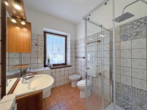 a bathroom with a sink and a toilet and a shower at BBkey Borgo Living Sutrio in Sùtrio