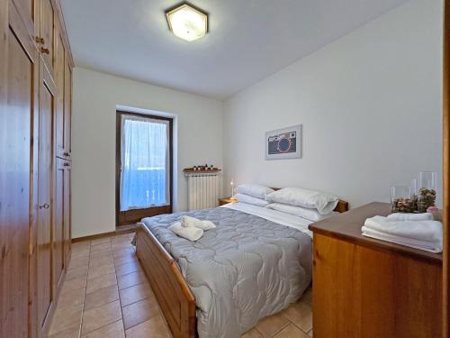 a bedroom with a large bed and a window at BBkey Borgo Living Sutrio in Sùtrio