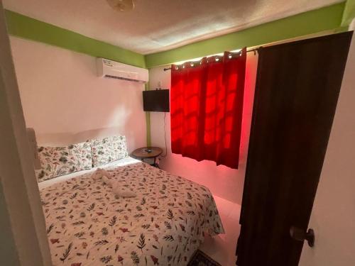 a bedroom with a bed and a red window at Caribbean Dream Vacation Property CD6 in Rodney Bay Village