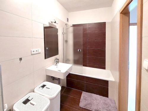 a bathroom with a sink and a toilet and a tub at Apartmán Všemina 300 in Všemina