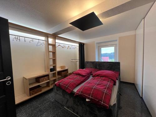 a bedroom with a bed with red sheets and a window at Zwischen Wald und Wiese in Lilach