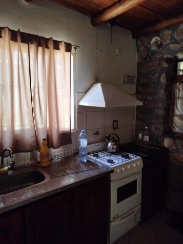 a kitchen with a sink and a stove top oven at Santa Mónica in Villa Giardino