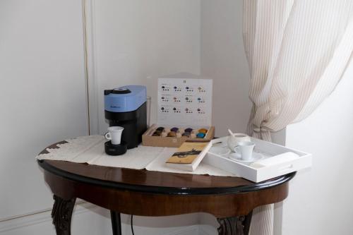 a table with a coffee maker and a box of donuts at Dimora delle Storie in Tempio Pausania