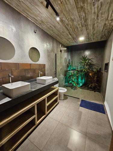 een badkamer met 2 wastafels en een plant bij Maison CATU in Itacaré