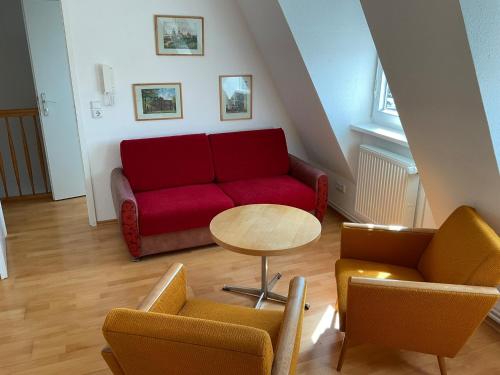 a living room with a red couch and chairs at Marienkirche 2 - ABC336 in Wismar