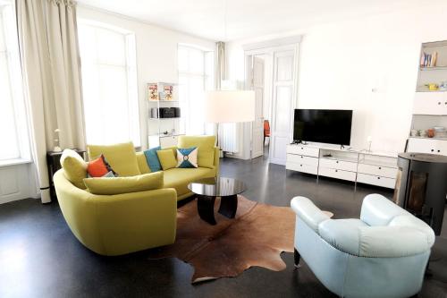 a living room with two chairs and a tv at Zuhause am Boulevard - ABC40 in Wismar