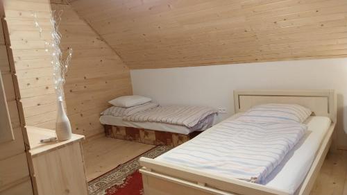 una stanza con due letti in una cabina di legno di Chata pod Kriváňom a Východná