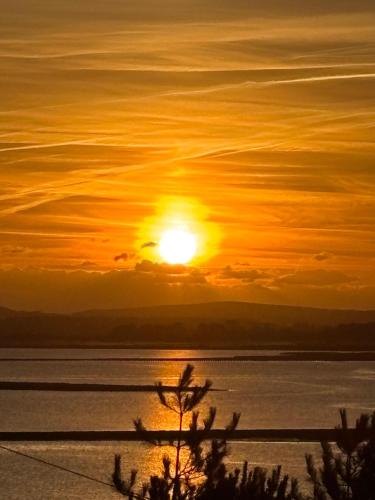 a sunset over a body of water with the sun at Rockley Park, Poole, Stunning Sea View, Close to Beach in Poole
