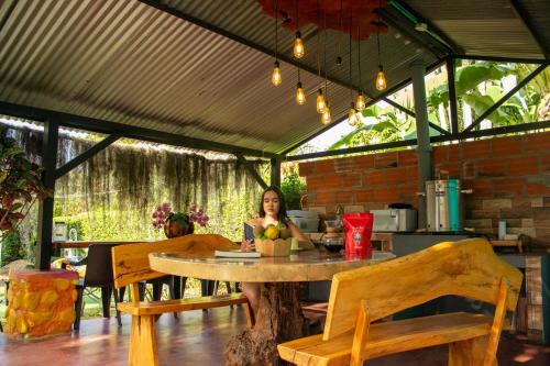 a woman sitting at a table in a pavilion at Cabañas Villa del Prado in Gigante