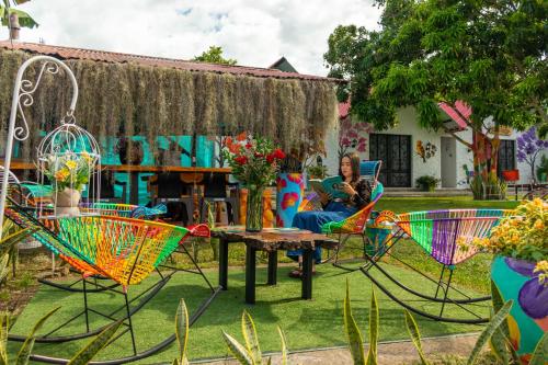 a woman sitting at a table in a garden at Cabañas Villa del Prado in Gigante