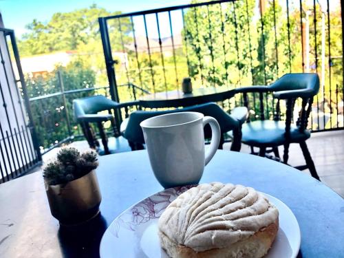 un tavolo con una tazza e un piatto con un dolce sopra di Casa del Olivo Suite 2 a Parras de la Fuente